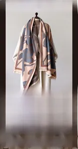 Close-up of pink and grey-blue thick scarf with floral patterns and fringed edges