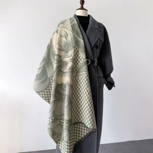 Green and beige checkered scarf with floral patterns and tassels on a mannequin