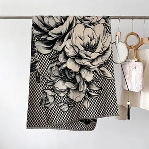 Detail of plaid cashmere-like shawl featuring large peony print and delicate fringe