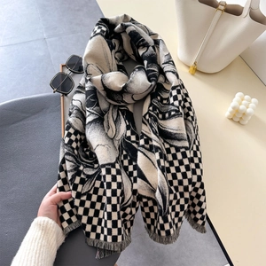 Detailed view of black and white checkered scarf with floral patterns and soft fringes