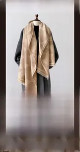 Detailed texture of geometric pattern scarf in camel and beige faux cashmere with tassels