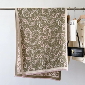 Detail view of paisley jacquard scarf with olive green pattern and fringe edges