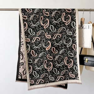 Detail of vintage paisley pattern on soft black shawl with delicate fringe and floral motifs