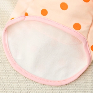 Close-up of pet shirt showing soft white fleece lining and orange polka dot pattern