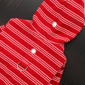 Detail of red striped pet hoodie featuring a metal D-ring and secure white snap buttons