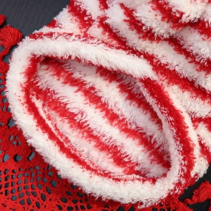 Detail of red and white striped plush coral fleece pet hoodie with soft furry texture