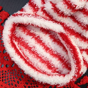 Close-up of soft red and white striped plush fleece fabric with thick warm texture