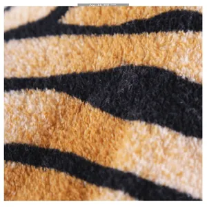 Macro shot of fluffy flannel tiger stripe fabric texture and soft plush fibers on pet clothes