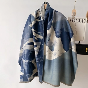 Blue and white landscape print cashmere-feel scarf with fringes on a wooden hanger
