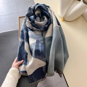 Blue and white abstract cashmere-feel scarf with tassels draped over a chair