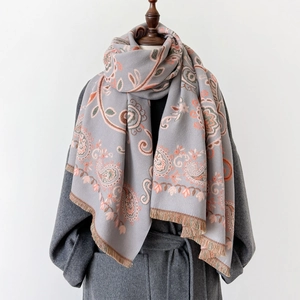 Élégant châle jacquard à motif paisley avec franges sur un manteau gris pour l'hiver
