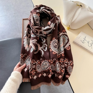 Détail d'une écharpe tricotée marron café à motif paisley et franges douces