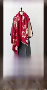 Detail of red winter scarf with yellow floral pattern and fringe on mannequin