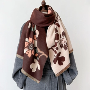 Elegant knit shawl scarf with large floral patterns and tassels on a grey wool coat