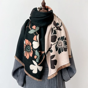 Detailed view of the double-sided shawl with bold floral patterns and fine fringe trim