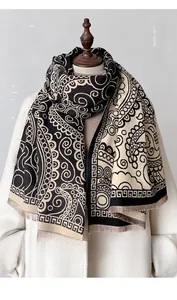 Vue détaillée d'une écharpe en cachemire à motifs paisley et bordures à franges