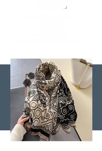 Détail d'un châle doux au toucher cachemire avec motif grec et texture en tricot paisley