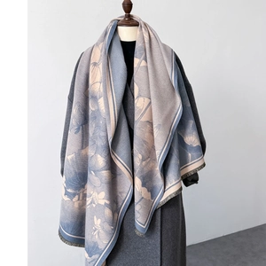 Detailed texture of lotus pattern scarf with soft fringe on a grey winter coat