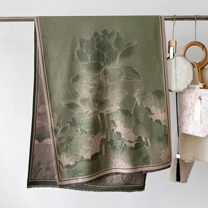Detail of dark green shawl featuring elegant lotus floral pattern and soft fringe tassels