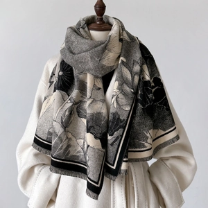 Detail of elegant black and white lotus shawl with fringe on white coat