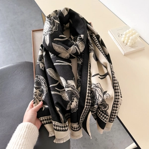 Detail of floral and houndstooth print scarf with soft fringe edges and premium texture