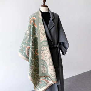 Elegant paisley print winter shawl with fringe tassels over a stylish wool coat