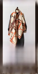 Détail d'un châle épais imitation cachemire avec motifs à boucles orange et bords à franges