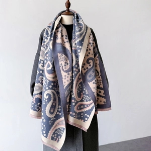 Detailed view of paisley and floral pattern print on soft winter shawl with fringe edge