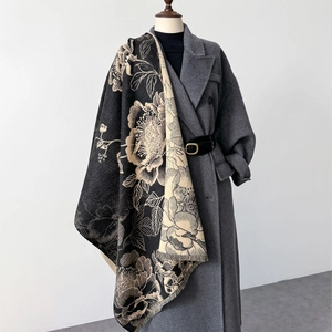 Elegant oversized floral shawl with fringe tassels draped over a grey coat for winter