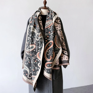 Close-up of paisley pattern shawl with fringe details and soft wool coat texture