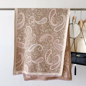 Detail of light brown paisley shawl with delicate pink floral patterns and fringe edges