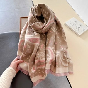 Close-up of winter paisley shawl with floral prints and soft pink fringe details