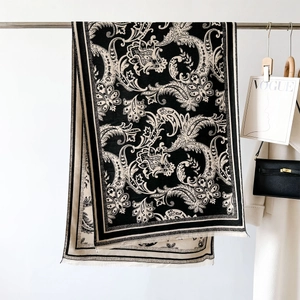 Close-up of black and white paisley pattern shawl with elegant tassel fringe detail