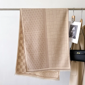 Close-up of geometric jacquard pattern and soft tassel edges on the beige warm scarf