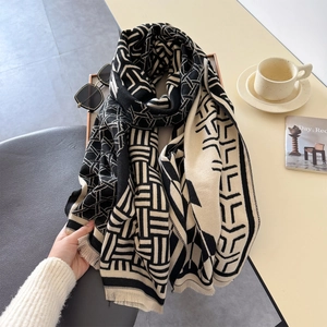 Modern black and white geometric pattern shawl with fine tassels on a lifestyle background