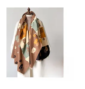 Close-up of thick cashmere-like scarf showing cute cat prints and tassel edge details