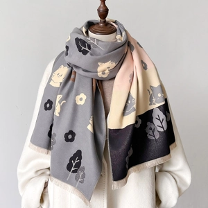 Cozy cashmere-feel scarf with cute cat patterns and tassels on a white coat