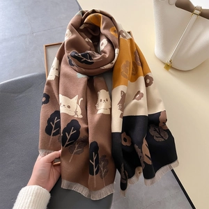 Detailed view of soft cashmere-like scarf with cat patterns and fine tassel edges