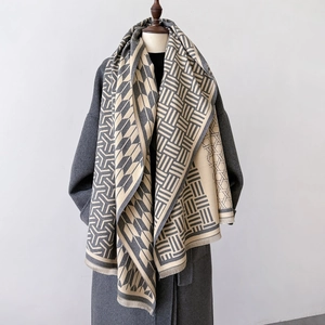 Double-sided plaid shawl scarf in beige and taupe with tassels on a dark coat