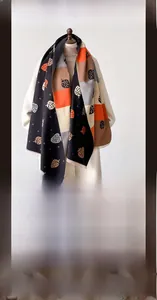 Detail view of strawberry motif scarf featuring patchwork colors and soft fringe edges
