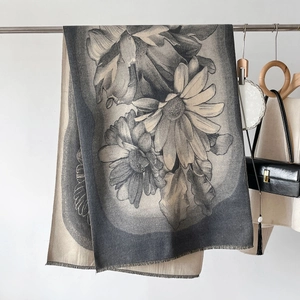 Detail of floral cashmere-like scarf showing contrast jacquard pattern and fringe edges