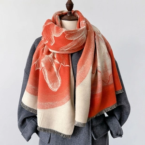 Orange and cream floral faux cashmere scarf with fringes over a stylish grey coat