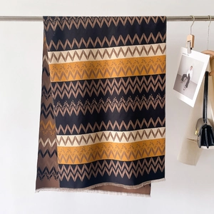 Detail of striped cashmere-like scarf with fringe edges and geometric pattern texture