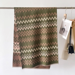Macro detail of the premium striped cashmere-feel scarf showing rich zigzag weave and fringe