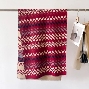 Close-up of geometric striped pattern and fringe detail on cashmere-like warm shawl scarf