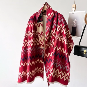 Classic red chevron patterned pashmina shawl with fringe tassels on a wooden hanger