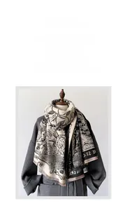 Detail of beige scarf with black lion print, plant textures and soft fringe accents