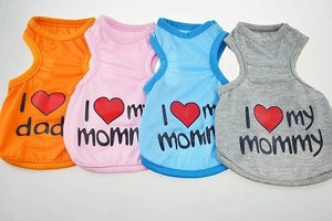 Detail of four colorful pet vests in orange pink blue and grey with heart print patterns