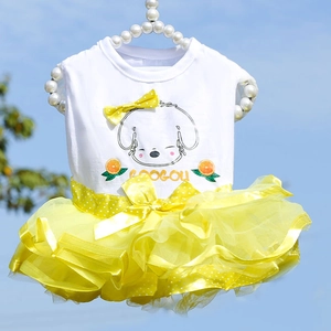 Detail of yellow tulle pet dress featuring a polka dot bow and cute cartoon graphics