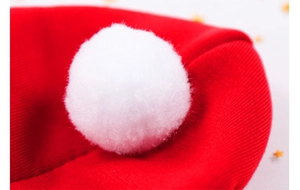 Détail d'un bonnet de fête tricoté rouge avec pompon blanc pour chiens moyens et chats
